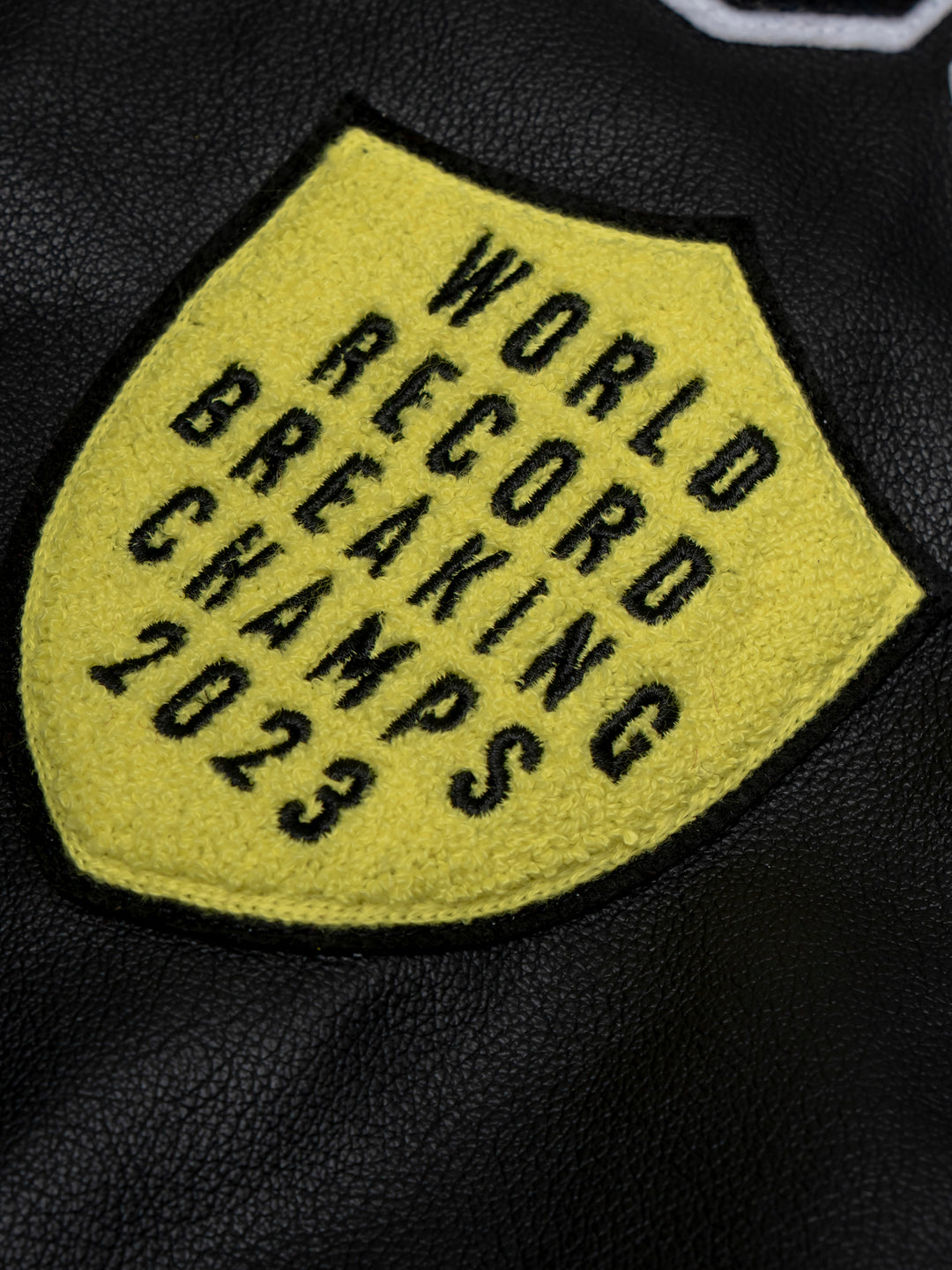 close up of a yellow patch that says: world record breaking champs 2023