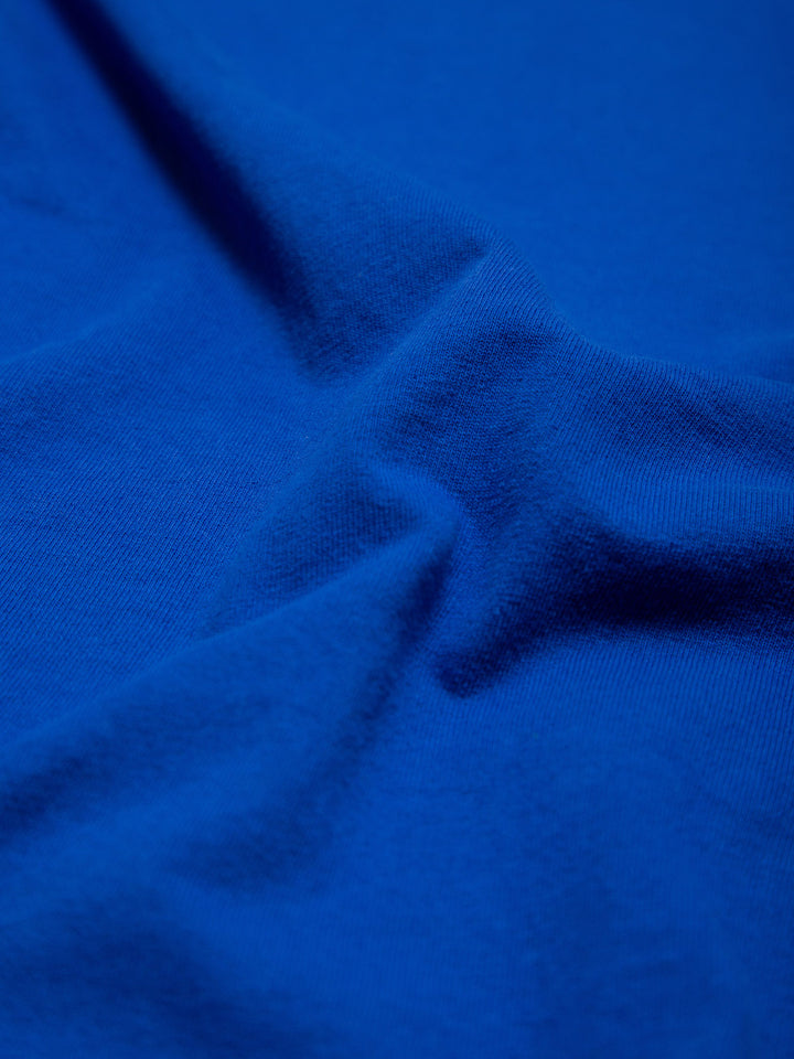 MORE THAN AN ATHLETE ATTRIBUTE TEE BLUE- close up of the blue fabric